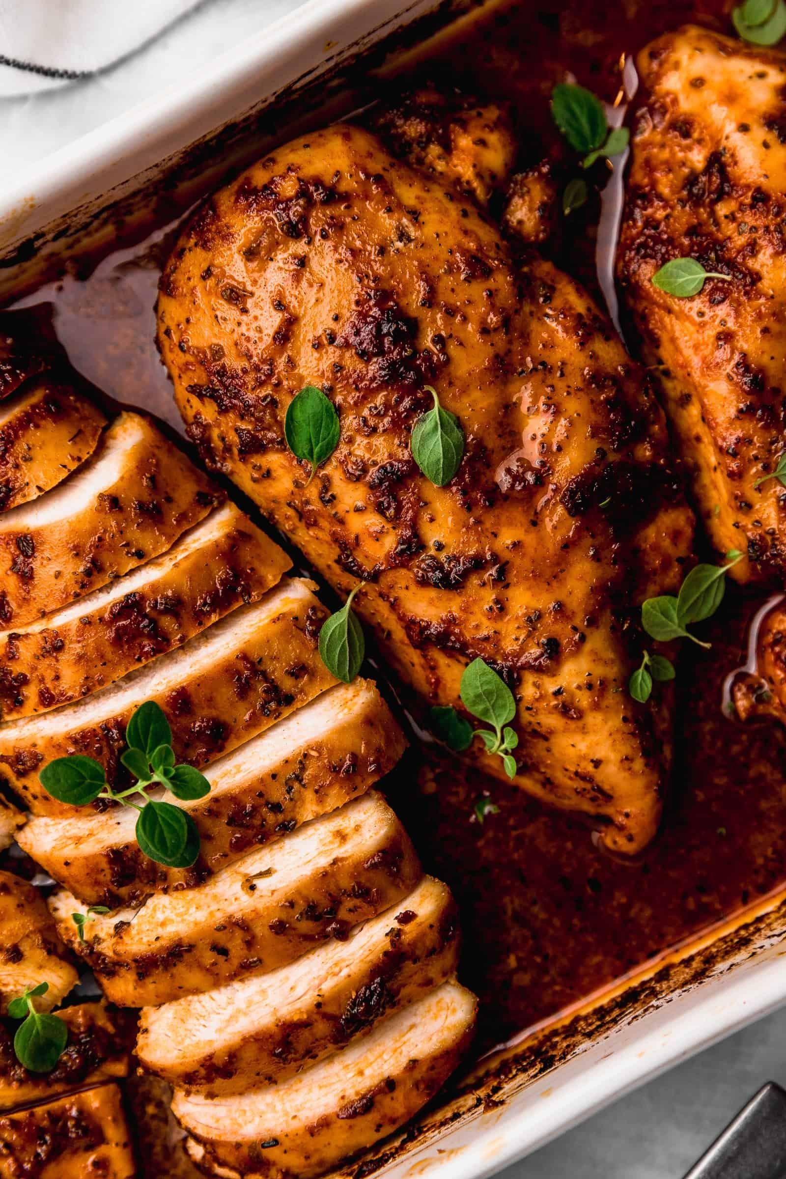Home cook preparing a whole chicken for roasting in a bright kitchen.