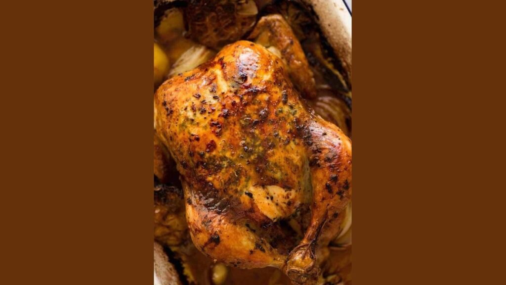 A golden roasted chicken sits on a platter as the best oven chicken.