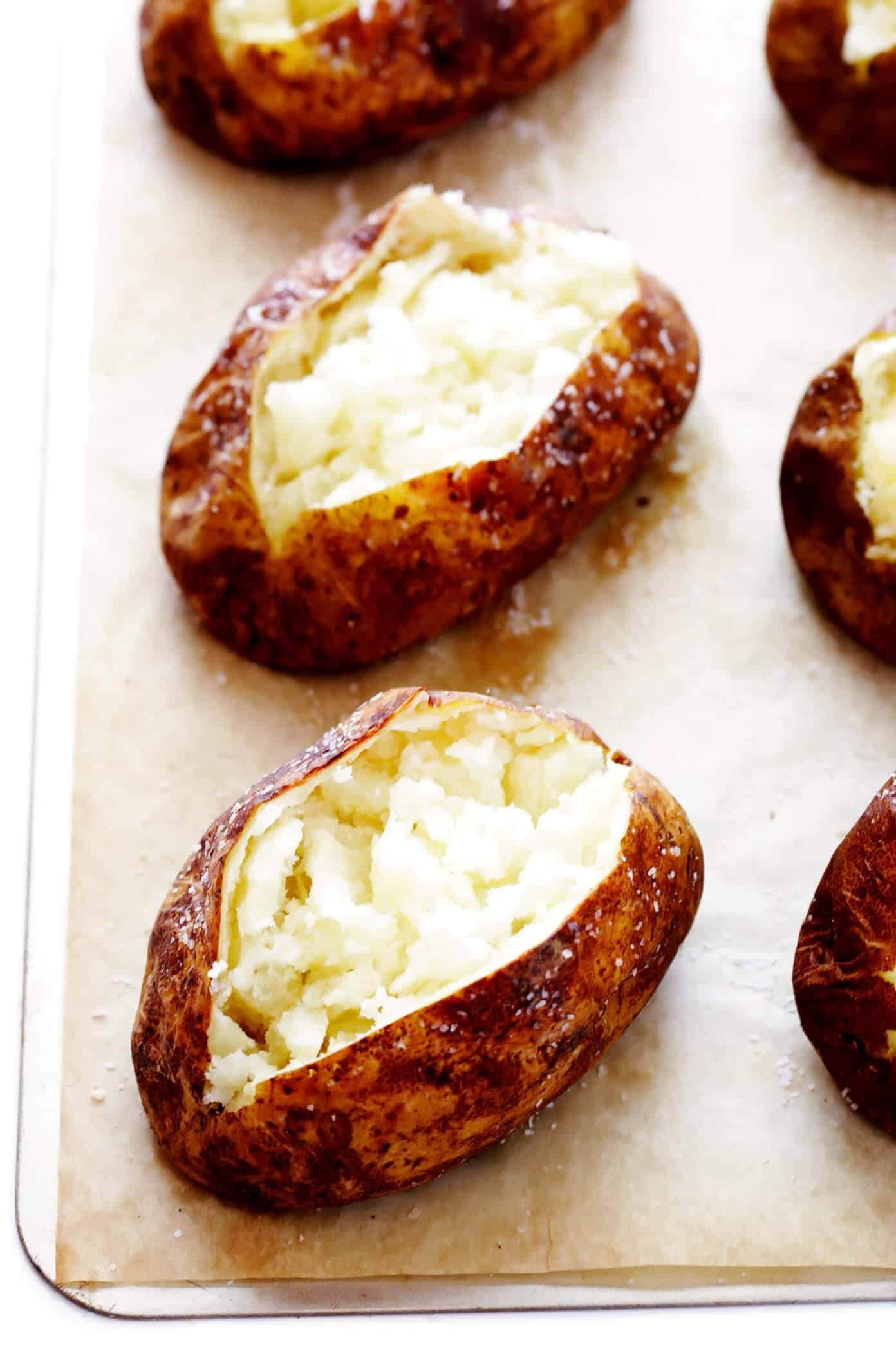 A burst potato on a baking tray showing common mistakes in jacket potato preparation.
