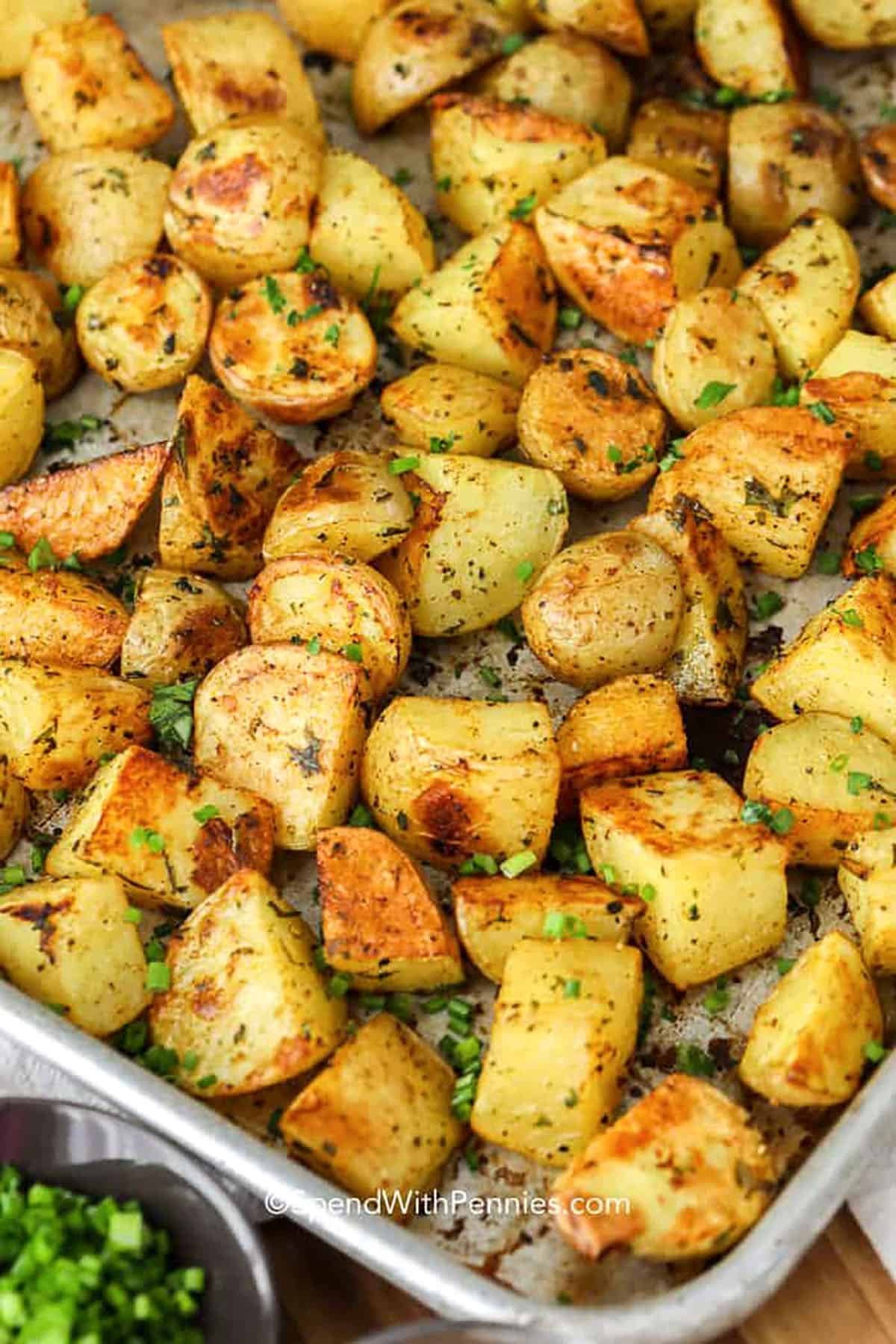 A stainless steel pan with perfectly spaced potato wedges ready for the oven.
