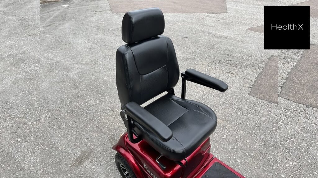 A person preparing to remove the seat from a modern mobility scooter.