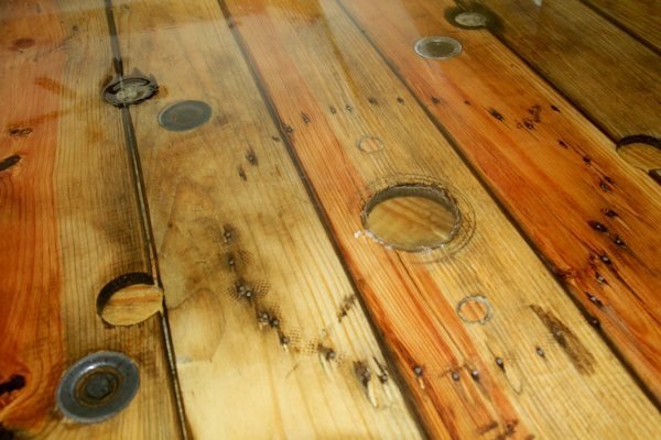 Repairing a deep gouge in a resin table with fresh epoxy resin.