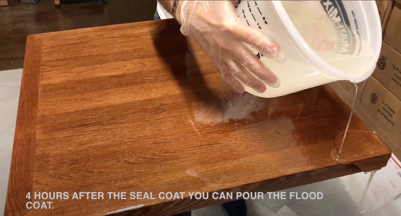 Essential tools and materials for sealing a table with epoxy resin on a workbench.