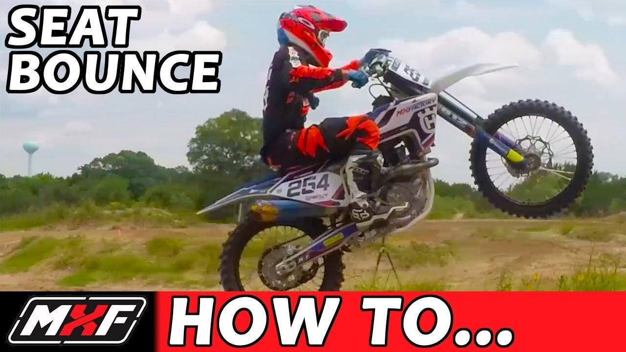 A dirt bike in a perfectly level arc during a successful seat bounce maneuver.