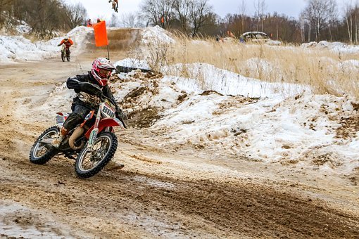 A dirt bike prepared for long-term storage in a bright, clean home garage.