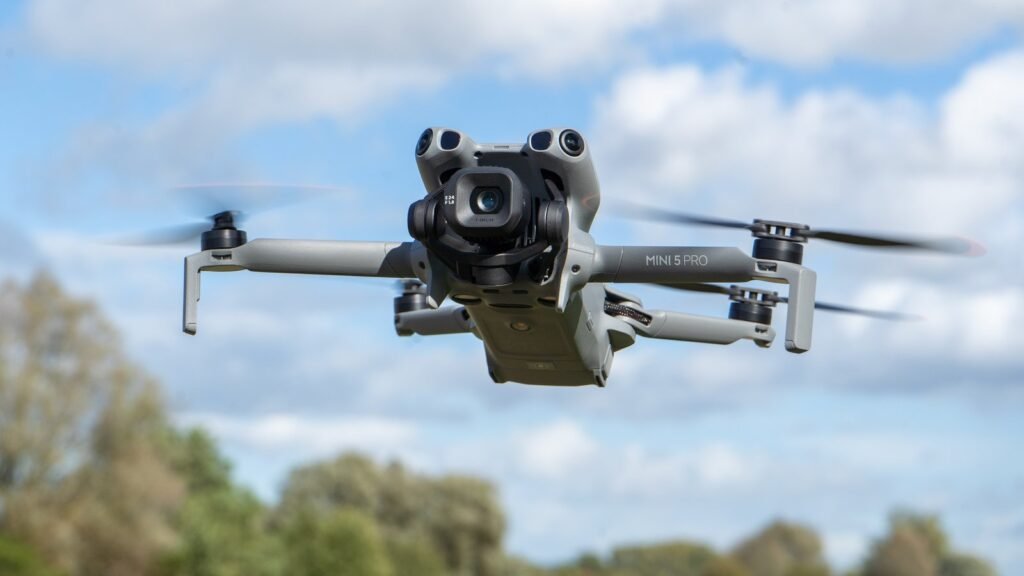 A modern drone with a high-quality camera hovering above a scenic mountain range.