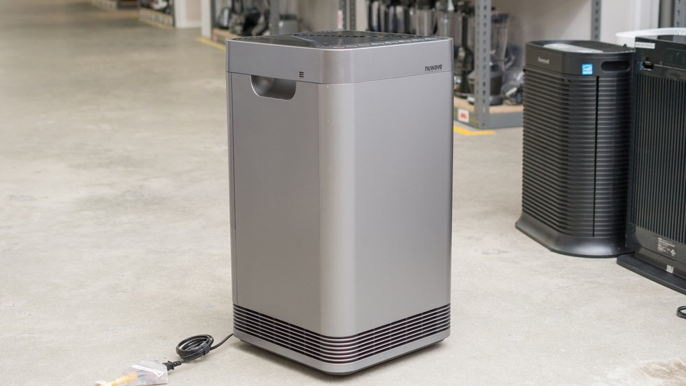 A modern NuWave OxyPure air purifier placed in a bright and minimalist living room.