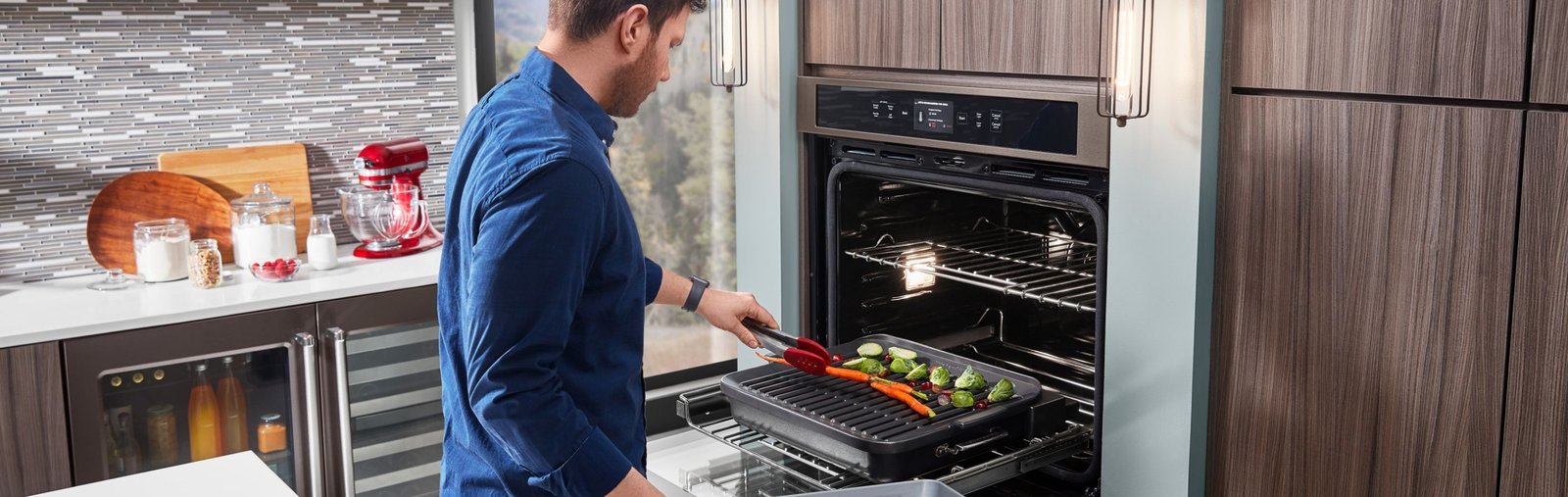 Chicken skewers browning under a glowing oven broiler element for grilling results.