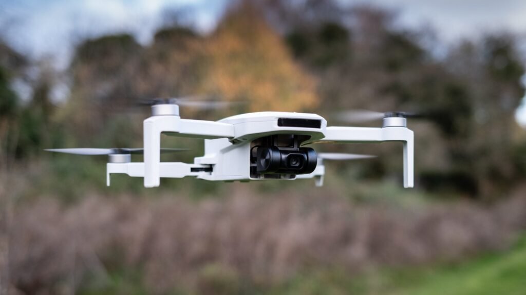 The Potensic Atom drone sits on a concrete surface during a golden hour.