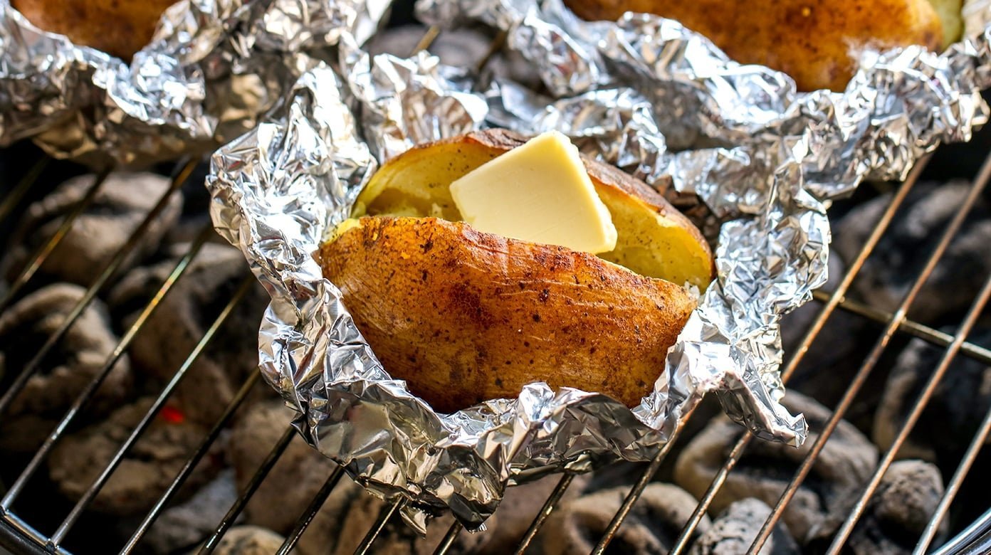 A halved baked potato with a thermometer on a plate showing cooking issues.