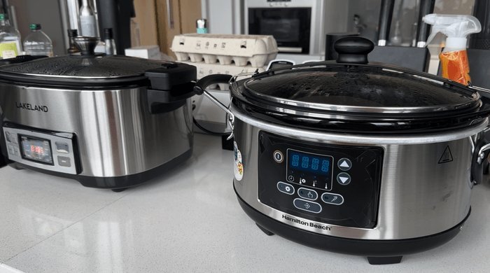 A person reading the safety manual for a slow cooker in the kitchen.
