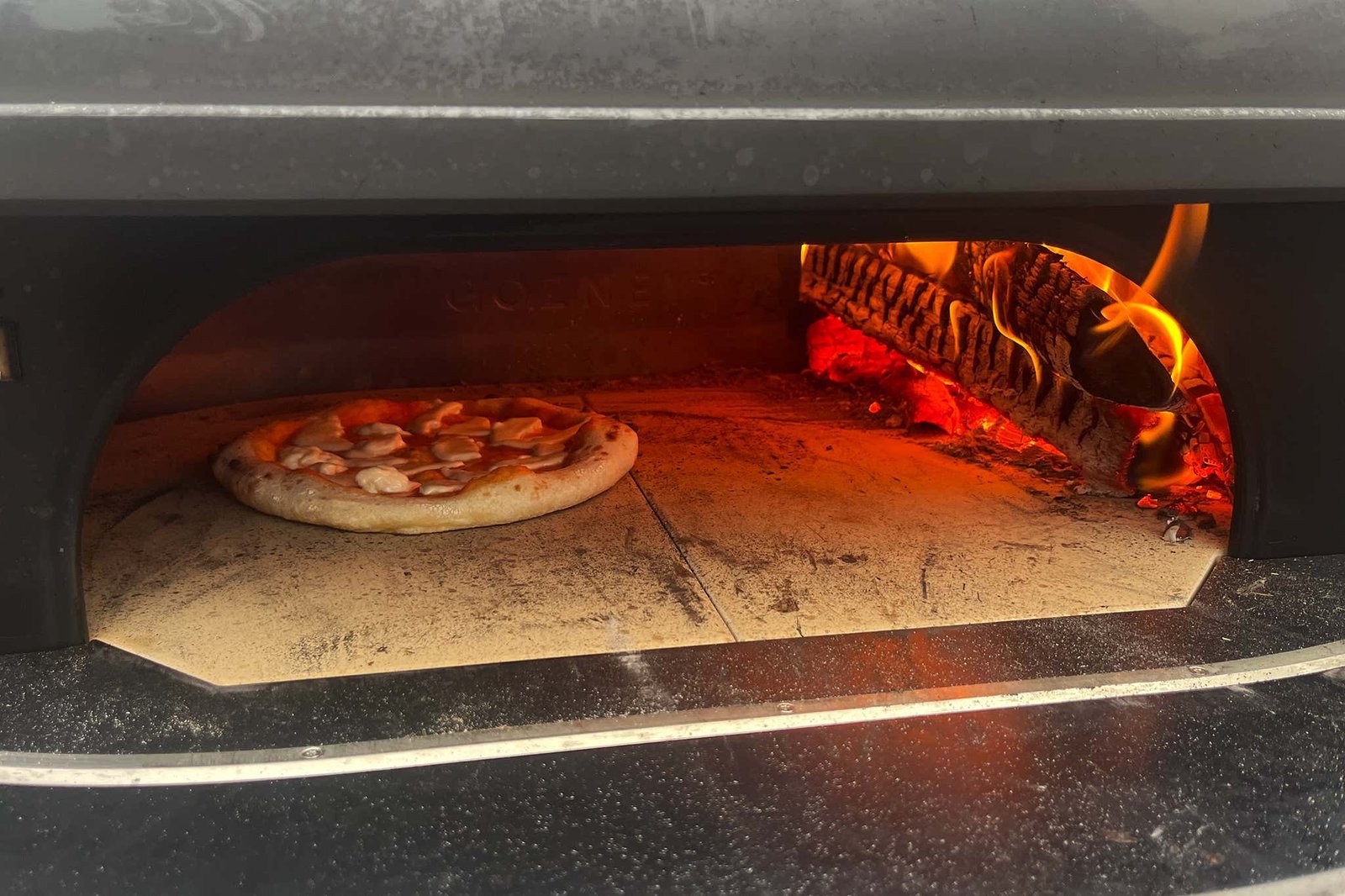 Cleaning a ceramic pizza stone carefully after it has cooled down completely.