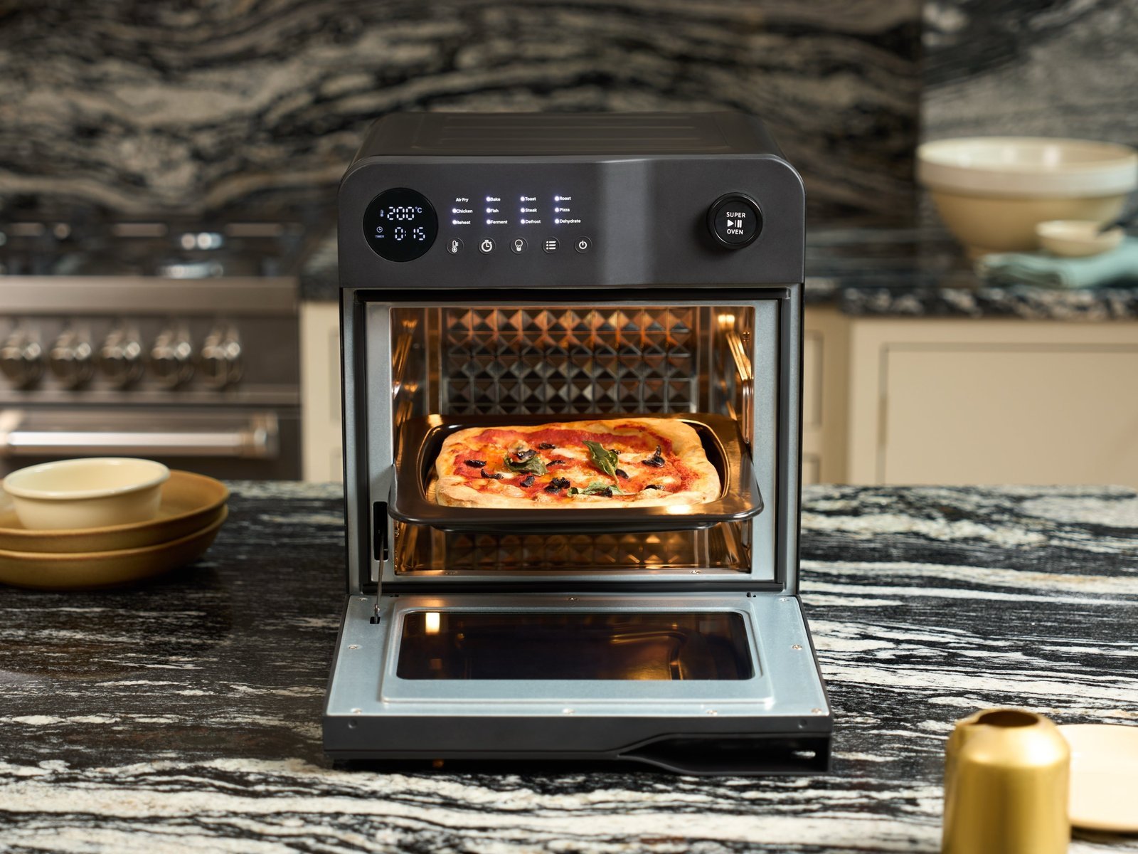 A neat kitchen counter features a compact oven and recipe books for appliance FAQs.
