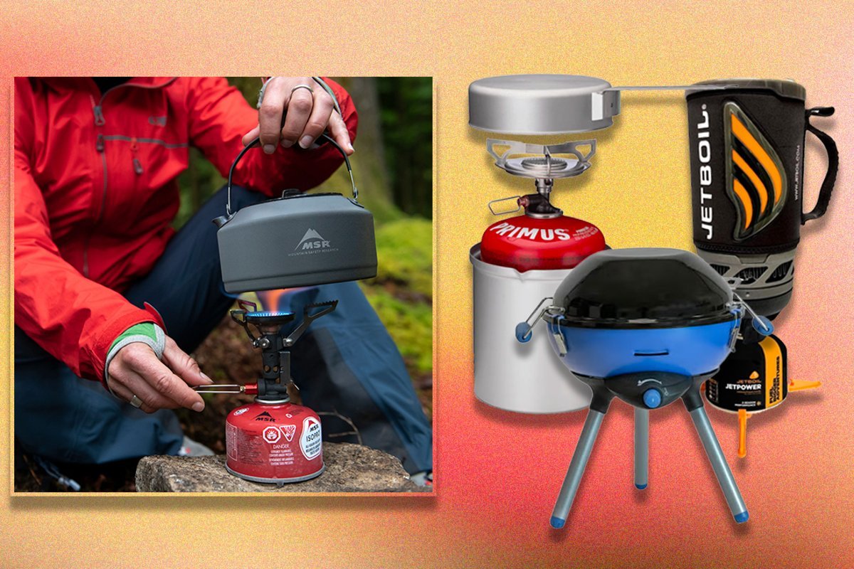 Hands cleaning the nozzle of a portable camping oven to ensure proper function.