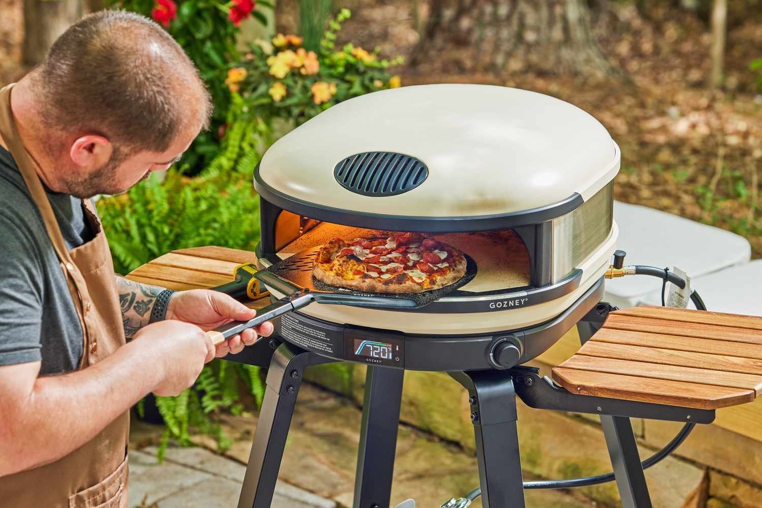 A clean food preparation area set up next to a portable pizza oven.
