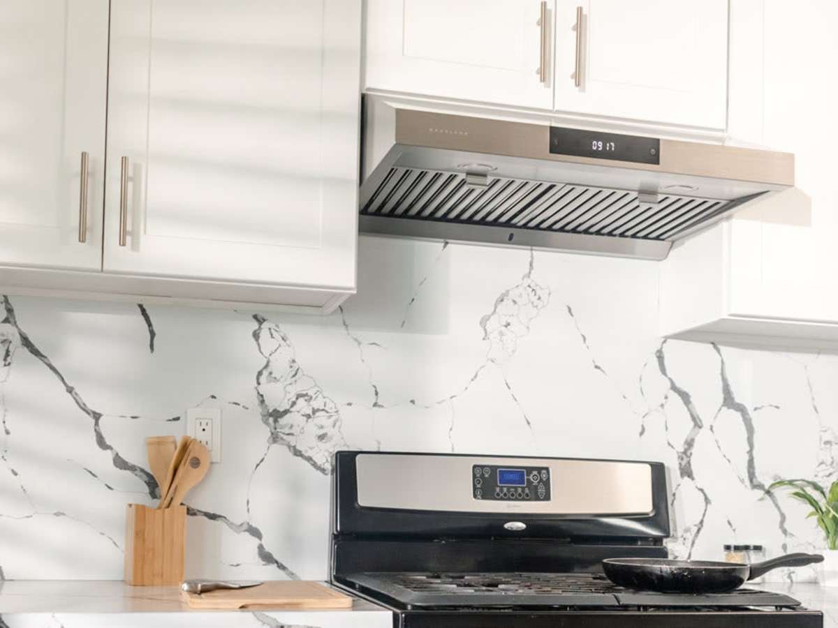 Steam rises from a pan toward an efficient range hood in a kitchen.