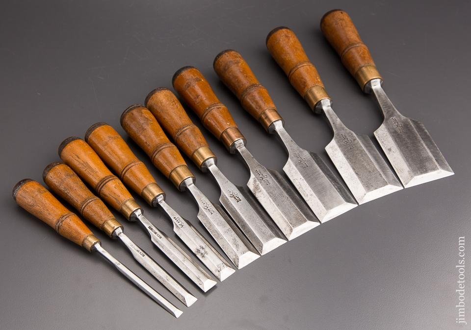 Woodworking chisels of different sizes arranged on a clean maple workbench.