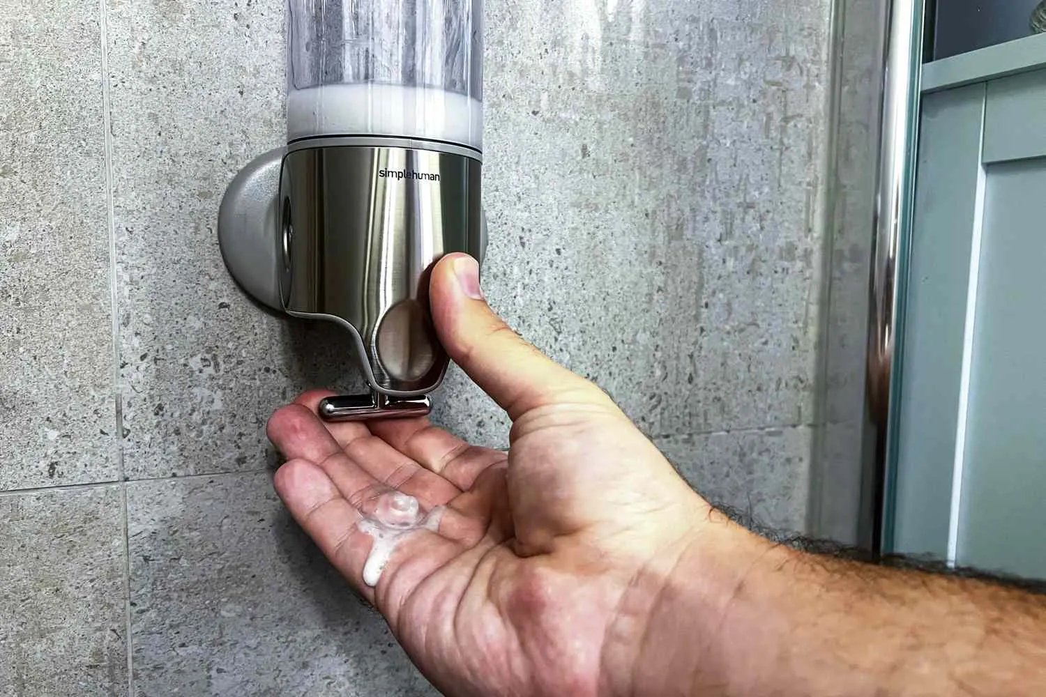 An automatic touchless soap dispenser placed on a modern bathroom sink surface.