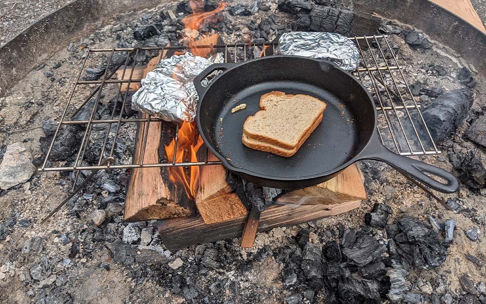 best camping pots for open fire displayed on a wooden table with natural elements