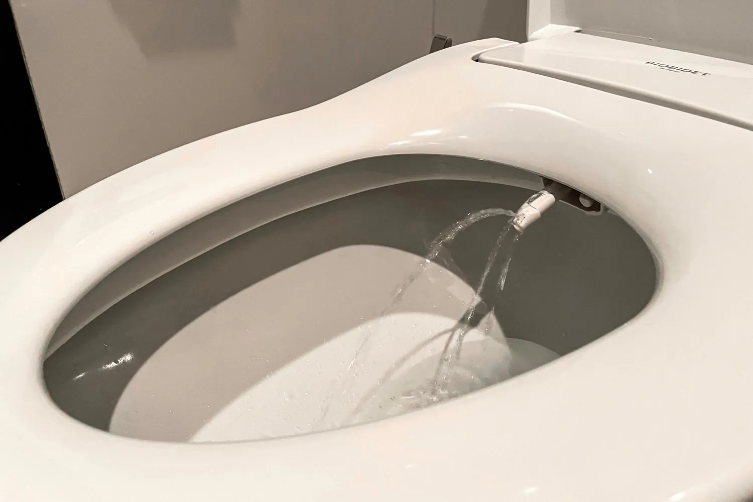 Bidet attachment with a mixing valve connected to a bathroom water supply.