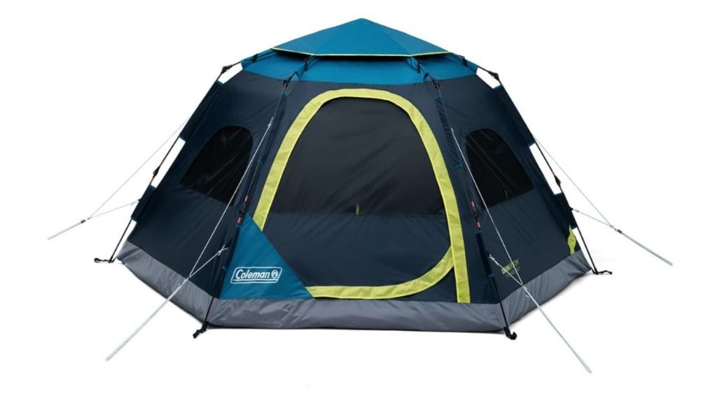 A blackout tent set up in a quiet backyard during evening light