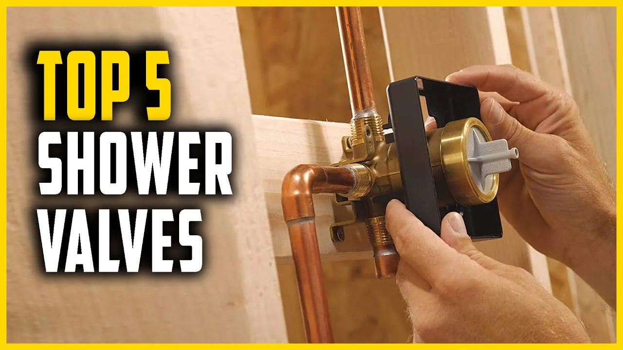 A brass shower valve being held during a bathroom plumbing renovation.