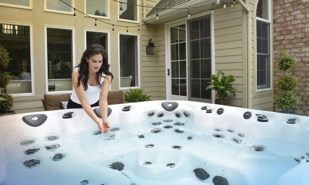 A broken floating chemical dispenser sitting in cloudy hot tub water.