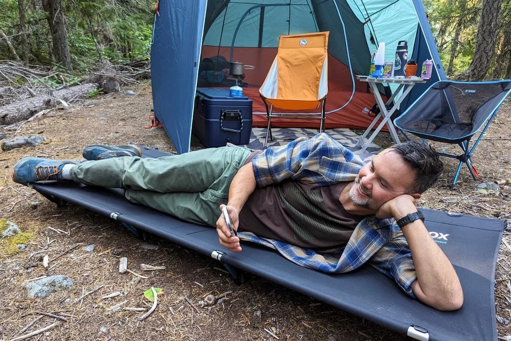 camping cot for side sleepers on a grassy campsite at dawn