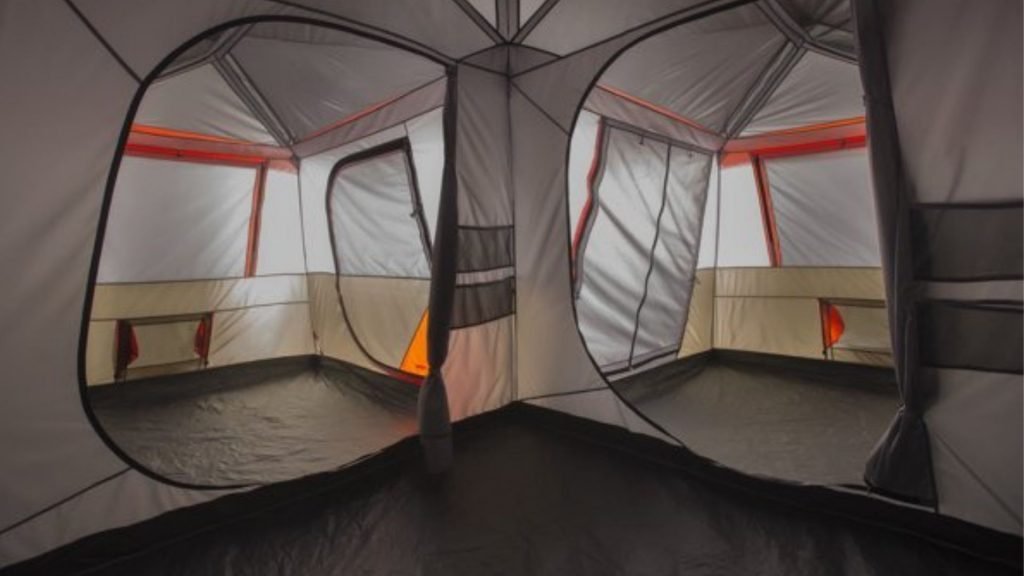 Camping tent with AC port pitched in a quiet forest clearing at dawn