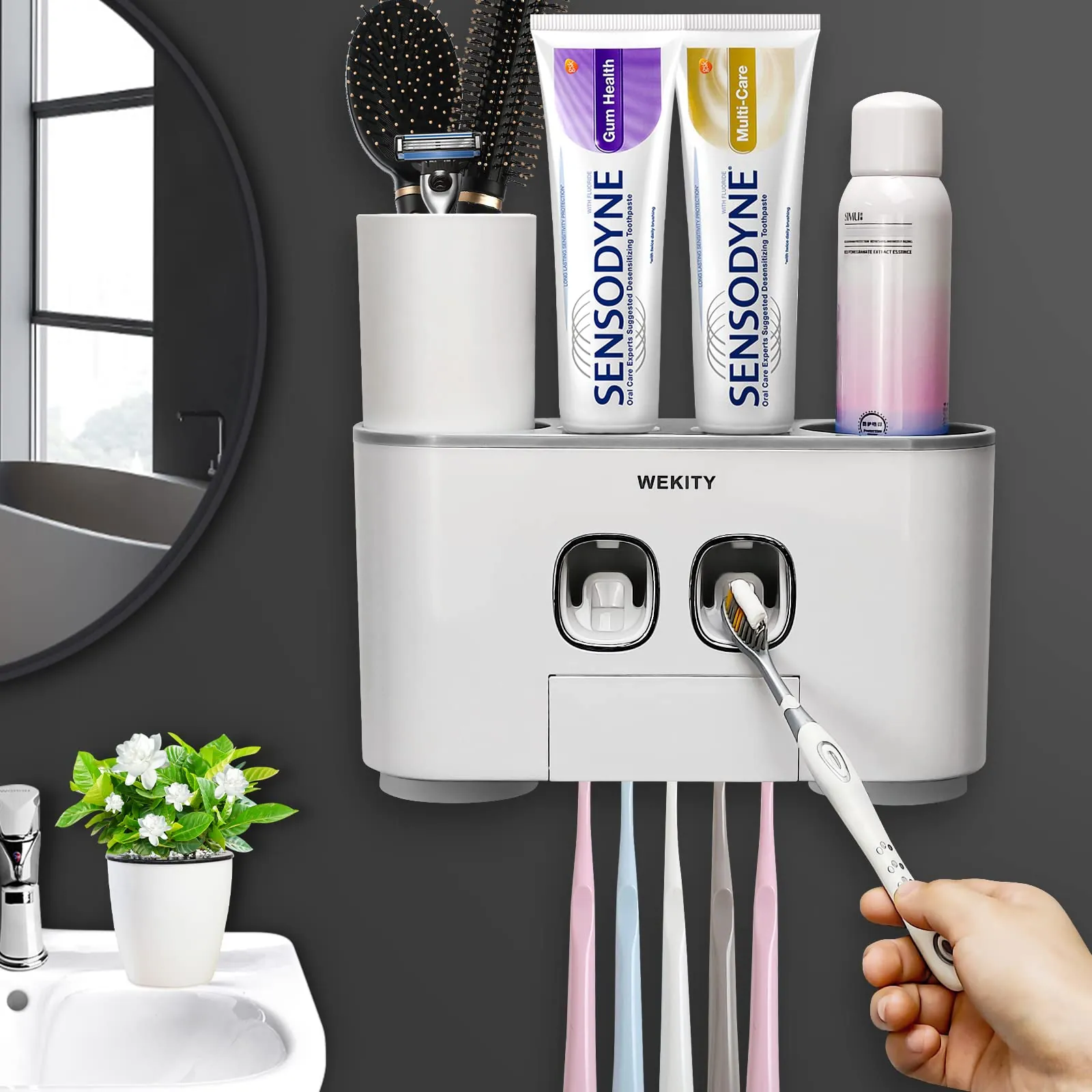 Ceramic and stainless steel toothbrush holders organized neatly on a marble bathroom sink.