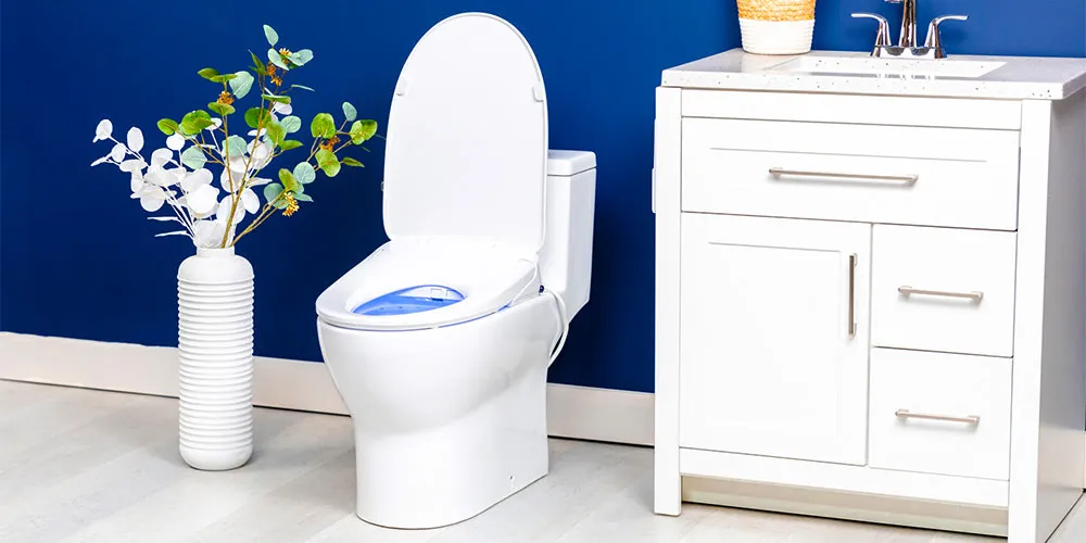 Checking for water leaks under a bidet installation with a paper towel.