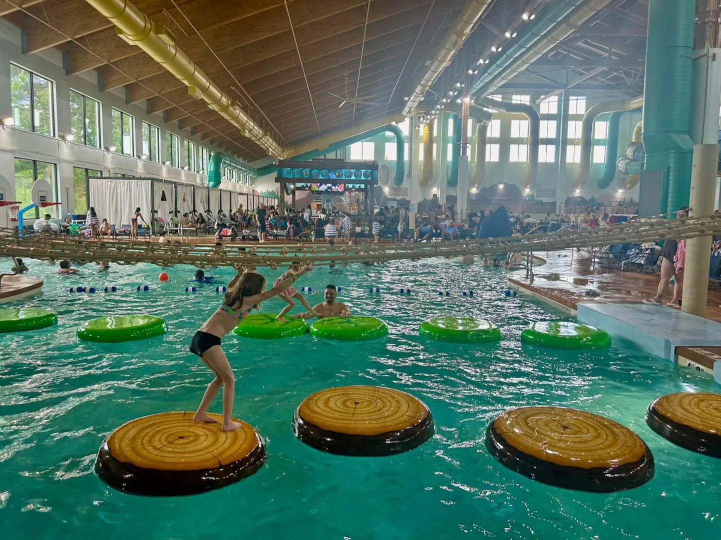 Child practicing school skills with a foam number in shallow pool water.