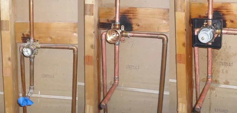 A chrome diverter valve installed for a multi-outlet shower system.
