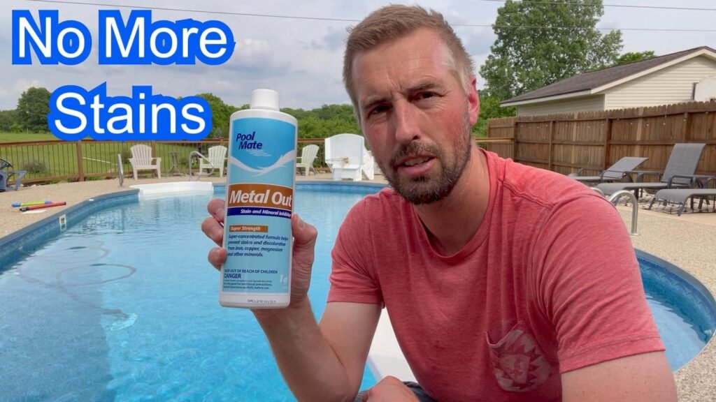 Clear blue pool with metal remover bottle on deck under soft natural light.