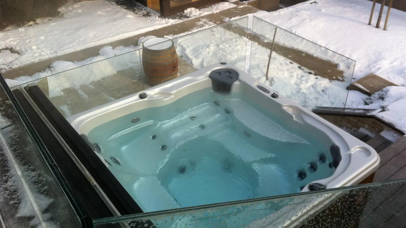Close up of a garden hose connected to a spigot filling a hot tub.