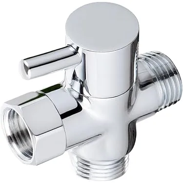 Close up of a polished chrome tub spout diverter pin in a bathroom.