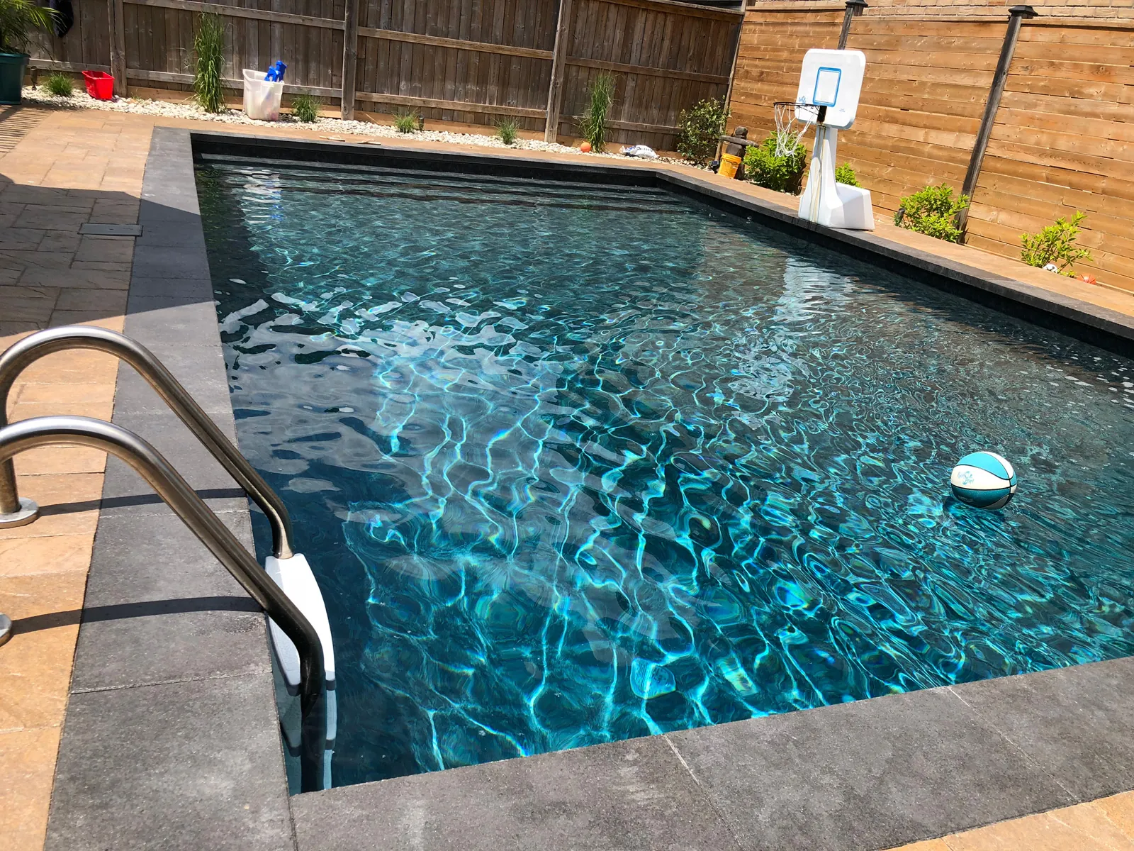 Close up of pool edge showing liner texture against stone coping.