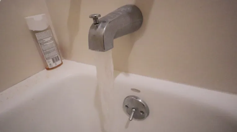 Close-up showing the difference between threaded and smooth copper bathtub plumbing pipes.