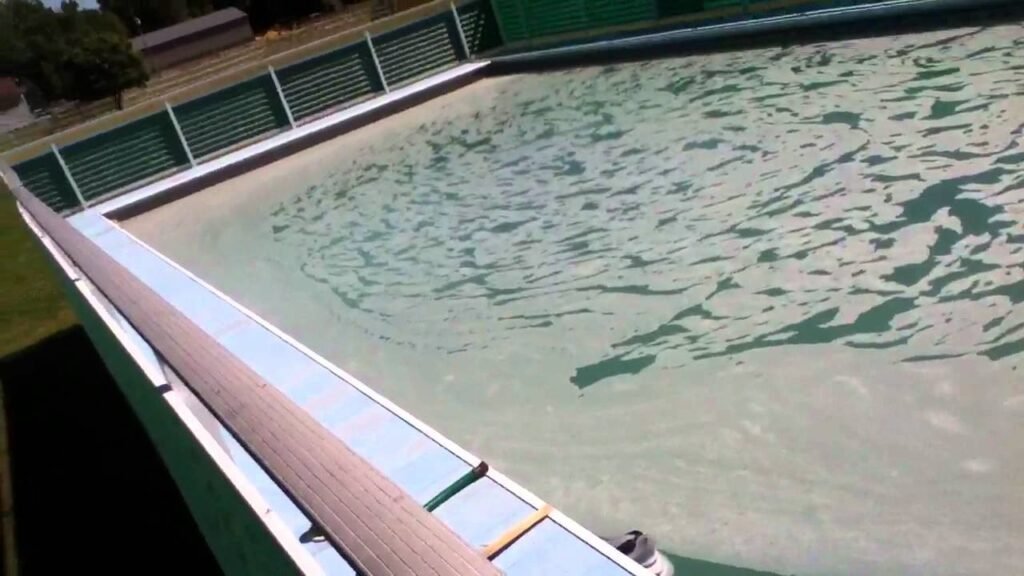 Cloudy backyard swimming pool showing the effects of too much clarifier in pool water.
