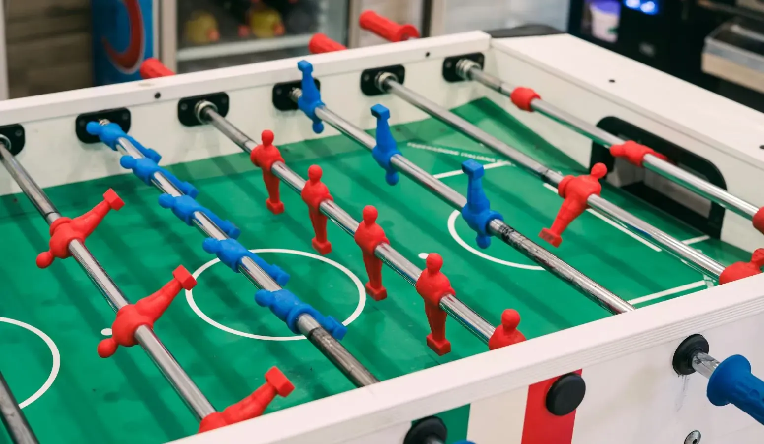 Detailed view of foosball table player rows including goalie defenders and forwards