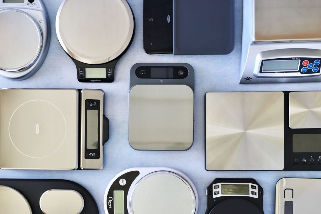 Digital food scale on a kitchen counter with baking ingredients nearby
