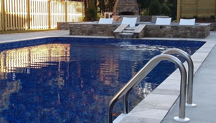 Empty concrete pool shell with three vinyl liner options nearby.