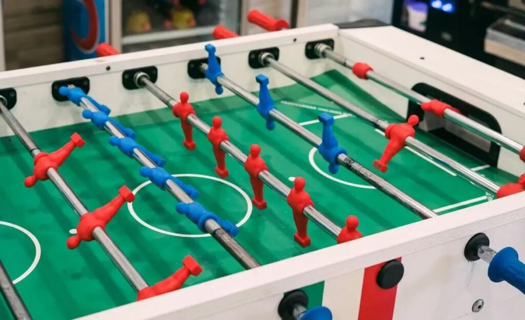 Foosball table showing rods and players in a bright modern room