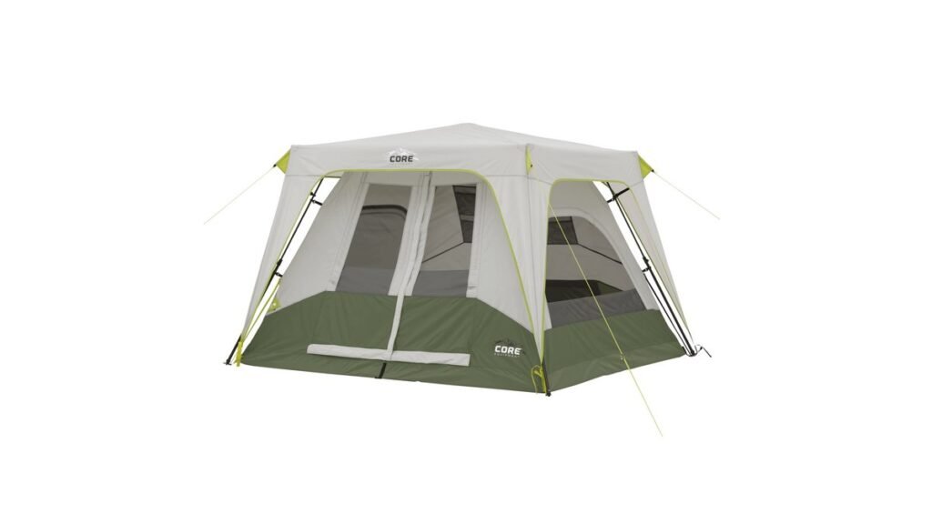 Four-person cabin tent in the rain, standing strong on a forest floor with water beading on the fly