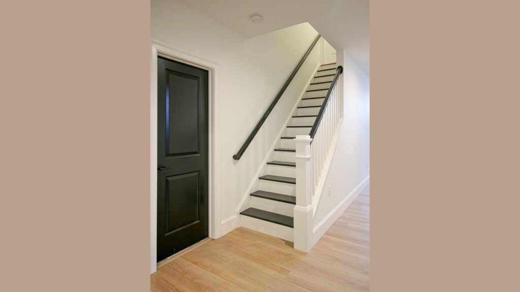 A freshly painted charcoal gray staircase in a modern home with soft natural lighting.