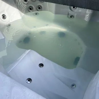 Hand gently tightening a loose union fitting on a hot tub pump