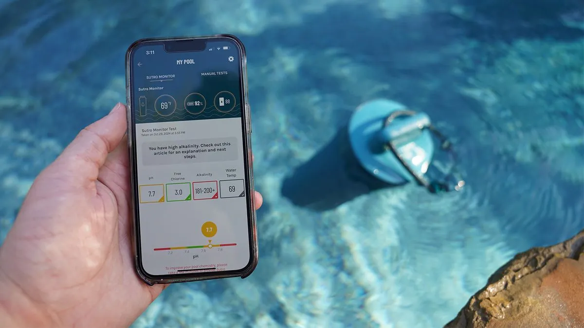 Hand placing WaterGuru sensor in pool water near a smartphone for connection