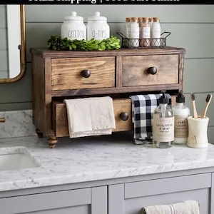 Hands cleaning a clear bathroom organizer bin as part of a regular maintenance routine.