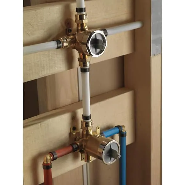 Hands holding a new shower diverter valve while planning a bathroom plumbing upgrade.