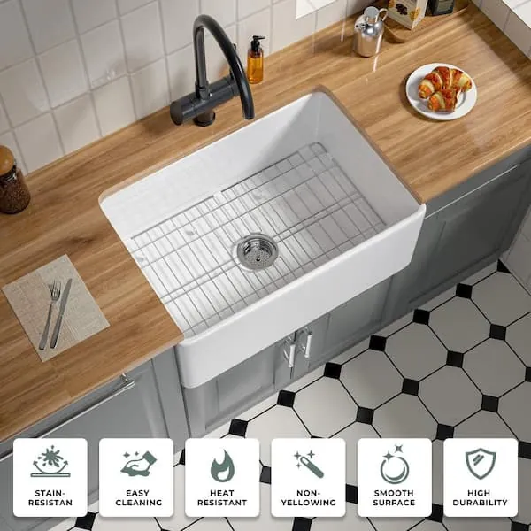 A heavy cast iron pan resting on a durable stainless steel sink grid.